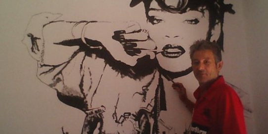 El pintor Rafael Aguilar amb una de les seves pintures sobre la cantant Rihanna