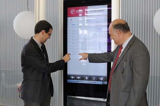 L'alcalde, Ignasi Giménez, i el director gerent de l'AOC, Joan A. Olivares, comprovant el funcionament del tòtem informatiu situat a El Mirador