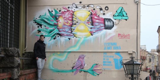 Marc Torrecilla, mostrant l'obra "Canalització ecològica", que es pot contemplar a les escales de la plaça Major que connecten amb el carrer Major.